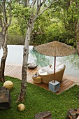 South Africa - bamboo shades and wicker chairs on a wooden terrace by a pool in a garden