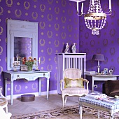 A living room with a Rococo chair and a country house-style wall table against a wall hung with purple and gold wallpaper