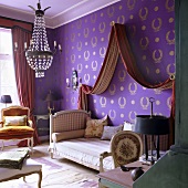 An antique sofa-bed with a canopy against a wall papered with purple wallpaper with a gold pattern