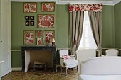 A bedroom with a fireplace and frame pieces of floral fabric on a green wall