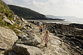 Spaziergang mit Kindern auf felsigem Weg an Meeresküste