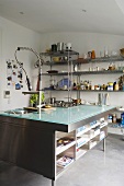 Cool materials - a glass-topped kitchen counter with a built-in stainless steel shelf with a modern tap