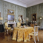 Esszimmer eines Palazzos mit antiken Kerzenständern auf Tisch und Stühlen im Rokoko Stil