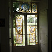 Antique stained glass window on a terrace door with shutters