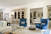 A Mediterranean living room with a blue winged chair and country house-style furniture