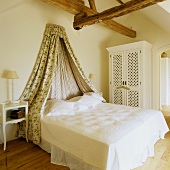 A marital bed with a canopy in a rural bedroom