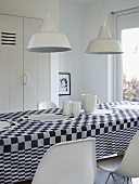 An arrangement of white crockery on a black and white checked tablecloth