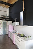 Offene Küche - Küchenzeile vor schwarzer Wand und Blick auf Galerie