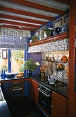 Ausgebaute Miniküche mit Mahagonyholzfronten und gefliester Wand