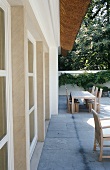 A view of a terrace with a table and chairs in front of a house