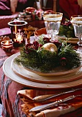 Christmas decorations on a place setting with wine glasses