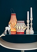 Chinese lanterns and candlesticks in front of a dark wall