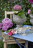 Garden flowers in antique stone containers and stone figurine