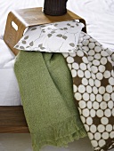 Wooden tray on a bed with pillows and patterned bedspread