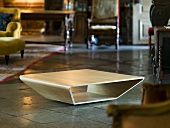 Floor table made from curved wood in front of antique period furniture