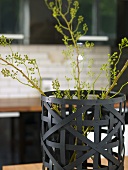 Paper basket made of black wickerwork with green twigs