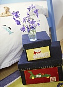 A detail of a child's bedroom with a painted bed, fabric covered toy storage boxes