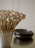A detail of an arrangement of dried poppy seed heads in steel pot
