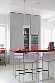 Barhocker und Theke mit roter Platte in moderner Küche