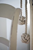 Zwei Seile mit Knotenende und Lehne eines Holzstuhls