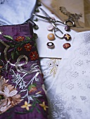 A detail of embroidered fabrics, buttons, scissors,