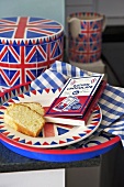 Fairy cakes on a plate next to a Union Jack tin