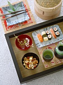Japanese food, sushi and other Japanese nibbles, bowls, beakers on wooden tray, square dish, chop sticks, ceramics, crockery