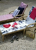 Outdoor wooden sun loungers set out on a gravel patio area, radio,