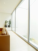 Sitting room with orange leather sofa and glass sliding doors.