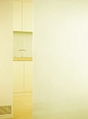View into kitchen with modern light coloured cupboard units.
