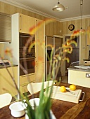 Wooden table in dining area of open plan kitchen with wooden units