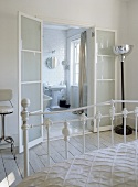 View through bedroom with Victorian bed frame to bathroom.