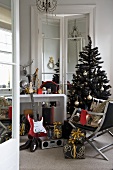 Musikinstrument und Geschenke vor Wandtisch und Weihnachtsbaum