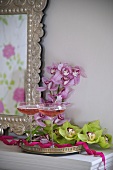 Gefüllte Champagnergläser und Orchideenblüten auf Silbertablett