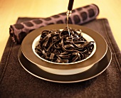 Brown tagliatelle on a brown and plate on a brown table mat