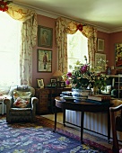 A traditional living room with an antique wall table and an upholstered armchair