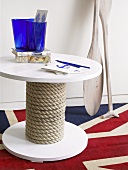 A round, maritime themed table and paddles on a Union Jack rug