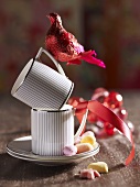 Two coffee cups one on top of the other with a bird figurine