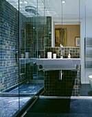 A modern bathroom with a designer wash basin and a mirrored cabinet next to a glazed shower area