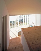 A stairwell with a view of the living room and a the glass facade