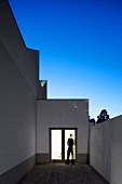 A roof terrace with an illuminated entrance in the evening