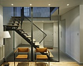 Moderne Lederstühle vor transparenten Trennwandpanelen im Treppenhaus