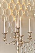 Burning candles in a candle holder against a wall decoration with porcelain, Rosenthal Casino, Selb