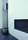 A built-in fireplace, a floor lamp by Jen Alkema and a mini television on the floor