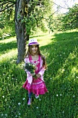 A girl with a dandelion clock in a field