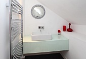 Waschtisch mit einem eckigen Waschbecken in einem weissen Badezimmer im Dachgeschoss