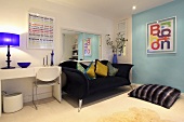 Decorative cushions on a dark blue sofa, a floor cushion and a white desk in a living room