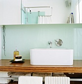 A wooden washstand with a square wash basin