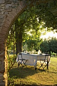 A view through an archway onto a table laid in a garden