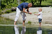 Vater und kleine Tochter spielen im See